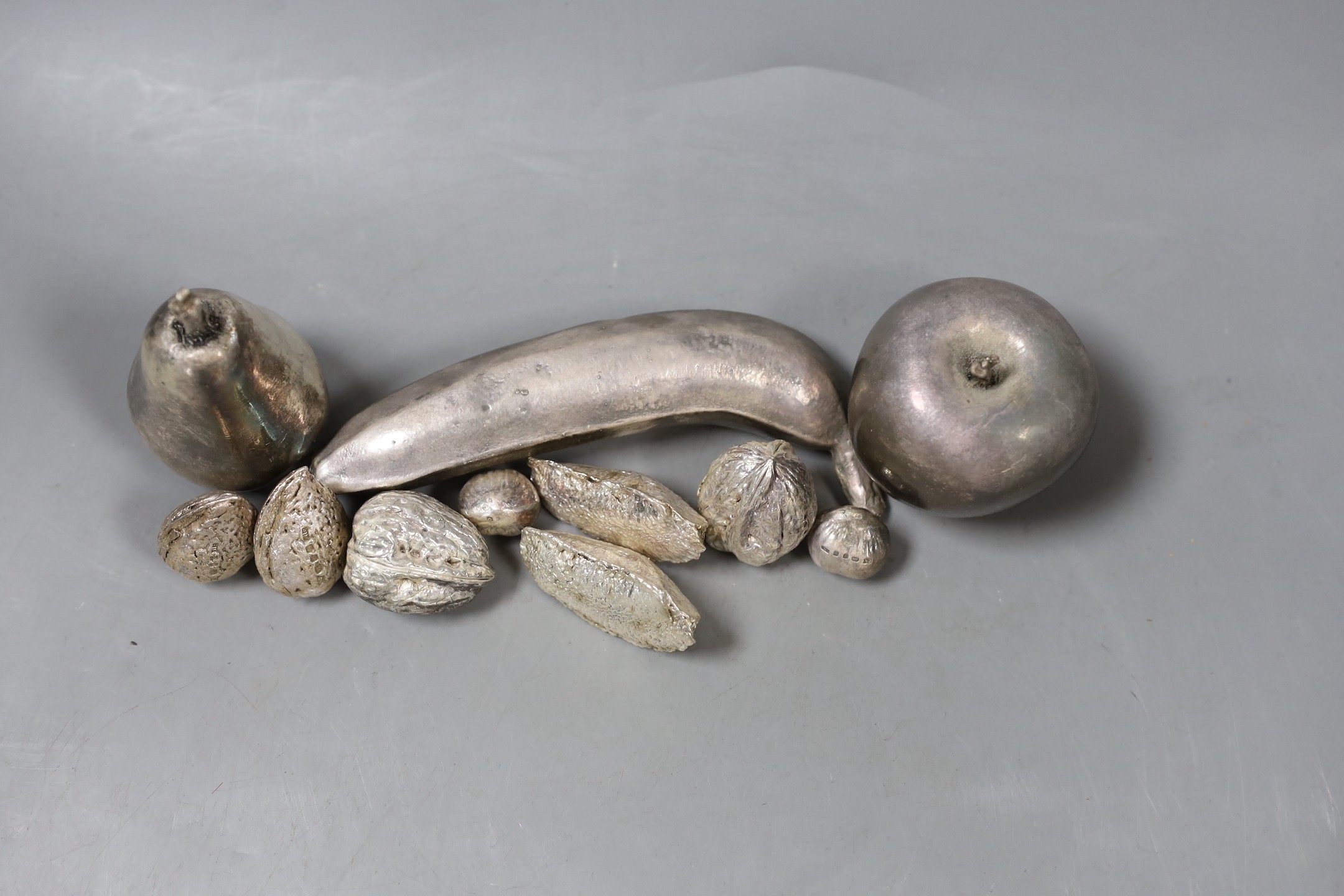 A group of novelty modern filled silver nuts, including Brazil, cob and walnut and three unmarked white metal fruits, banana 15.1cm.